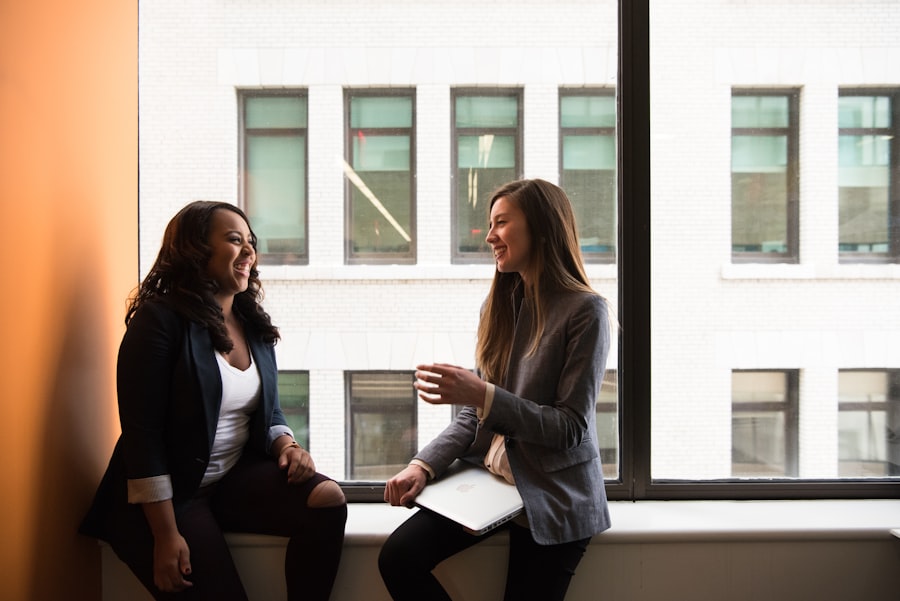 Two professionals in a calm, unhurried one-to-one conversation by a window
